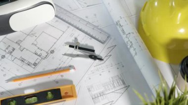 Mimari işyeri üst görünümü. Mimari proje planları masa üzerinde, mühendislik müteahhitlerinin tasarım için araç çalışma çizimi ve VR gözlükleri, sanayi sanal teknolojisi