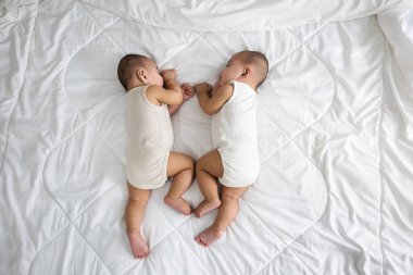 Mutlu çocukluk, uyuyan yeni doğan tek yumurta ikizleri yatak odasında, Asyalı iki sevimli ikiz oğlan, aile çocuğu