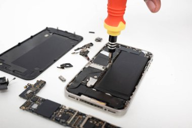 Technician repairing inside the smartphone motherboard with tools for recovery, The man repair by tightening nut from mobile phone with a screwdriver to fix problem