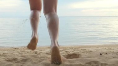 Geriye bakış, bikini mayo giymiş genç güzel bir kadın kumsalda tropikal sulara koşuyor mutlu Asyalı bir kadın tatilde dışarıda koşuyor yaz tatili konsepti