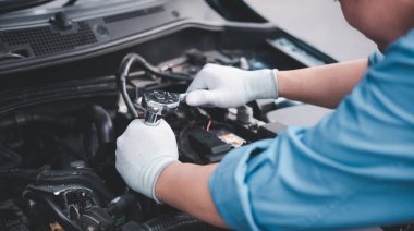 Service outdoor. Asian auto mechanic man working on car engine using wrench to repair and maintenance, broken car care check and fixed the problem and services insurance