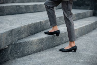 Stepping going up stairs in city, Closeup legs of businesswoman hurry up walking on stairway, rush hour to work in office a hurry in morning, foot of business woman wear black shoes step up success
