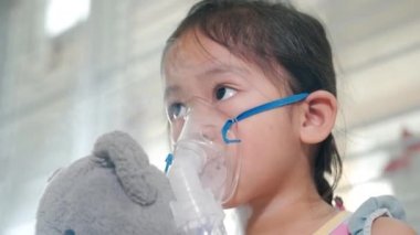 Kid girl making makes inhalation nebulizer steam sick cough at home, Asian Child using nebulizer mask equipment alone have smoke, stuffy nose and runny, oxygen spray inhaler therapy, Health medical