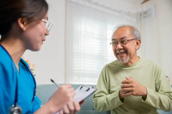 Enfermera Joven Asiática Que Escribe Prescripción Durante Visita Domiciliaria Anciano — Foto de Stock