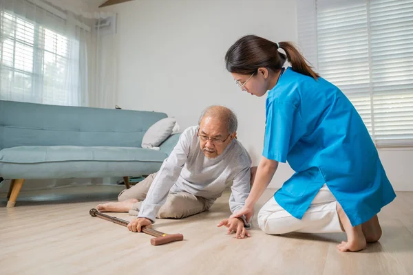 Asian older senior man falling down on lying floor and woman nurse came to help support, Disabled elderly old man patient fall down and caring young assistant at nursing home
