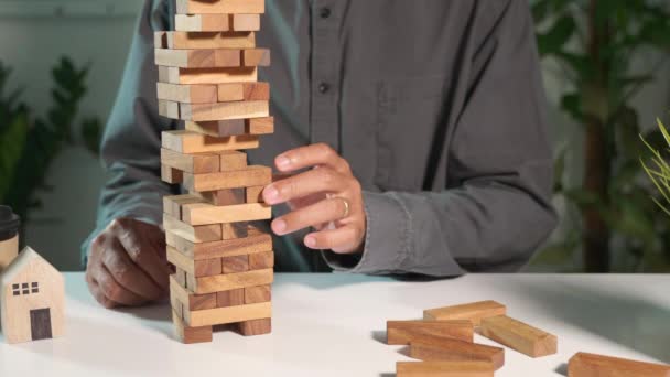 商业失败危险建设塔挑战游戏建设 商人伸手拔出木块 塔倒塌了 他的战略决策是错误的 — 图库视频影像