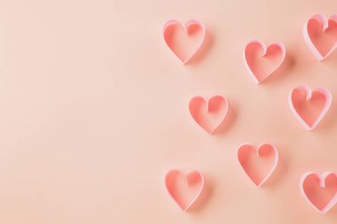 Top view flat lay pink ribbon heart shaped decorative symbol on pastel pink background, love romance concept, banner design with copy space, Mother, Woman day, Happy Valentines Day