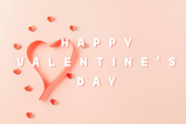 Top view flat lay of Ribbons shaped as heart and paper elements cutting red hearts flying on pink background, Banner template greeting card design of holiday, Love and Valentines Day background