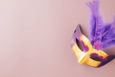 Happy Purim carnival. Carnival mask for Mardi Gras celebration isolated on purple background banner design with copy space, jewish holiday, Purim in Hebrew holiday carnival ball, Venetian mask