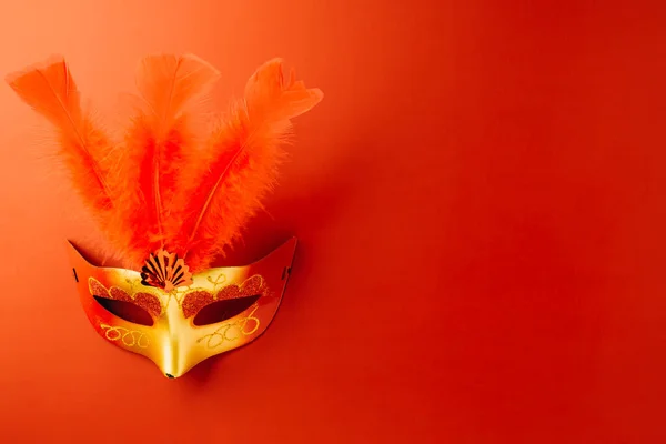 Happy Purim carnival. Carnival mask for Mardi Gras celebration isolated on red background with copy space, jewish holiday, Purim in Hebrew holiday carnival ball, Venetian mask, masquerade accessory