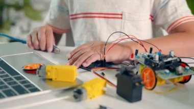 Küçük çocuk USB veri kablosu araba oyuncağına programlama kodu için, Asyalı çocuk programcı Arduino robot araba ev ödevi projesi için, STEAM eğitim yapay zeka teknolojisi dersi dersleri