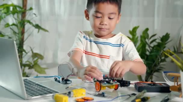 Asian Kid Boy Assembling Board Arduino Robot Car Homework Little — Vídeo de Stock