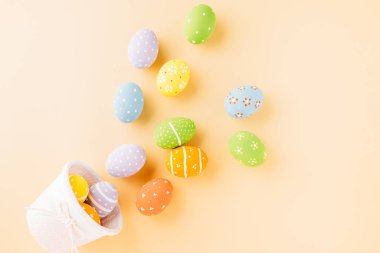 Top view easter eggs in basket filled fall down spread isolated on pastel background, Happy Easter Day, Creative composition banner web design holiday background, flat lay top view
