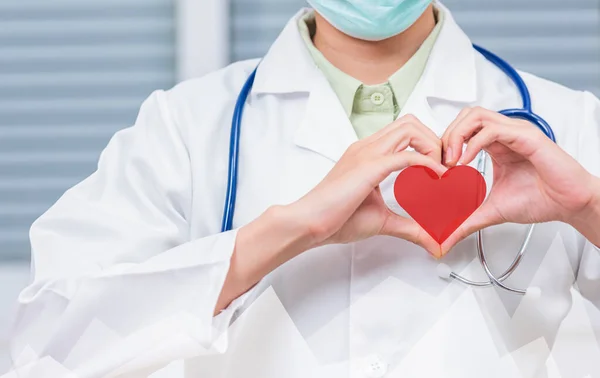 Doctor Day Concept. Doctor woman wearing uniform and stethoscope she making heart finger shape, Doctors hand sign, Healthy medical heart, treatment of heart diseases by palms