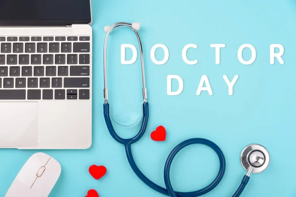 Doctors Day concept, flat lay doctor stethoscope with laptop computer and diagnosis heart disease isolated on blue background with copy space for text, Medical and Health care insurance