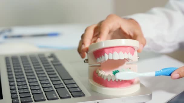ノートパソコンで医師の診察後に患者に正しく歯を磨く方法を説明する歯科指導 指導的なブラッシングの動きを示すチュートリアル歯をきれいに歯科衛生 — ストック動画