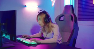 Kazanmak. Happy Gamer 'ın genç oyuncuları çevrimiçi bilgisayar oyunu oynuyorlar. Turnuvayı kazanmak için ellerini kaldırıyor. Oyun kulaklıkları takan genç bir kadın internette video oyunu oynuyor.