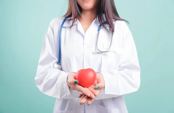Doctor Day, beautiful nurse young woman smiling with doctor stethoscope holding red head on hand isolated on blue background with copy space, Medical healthcare staff service concept