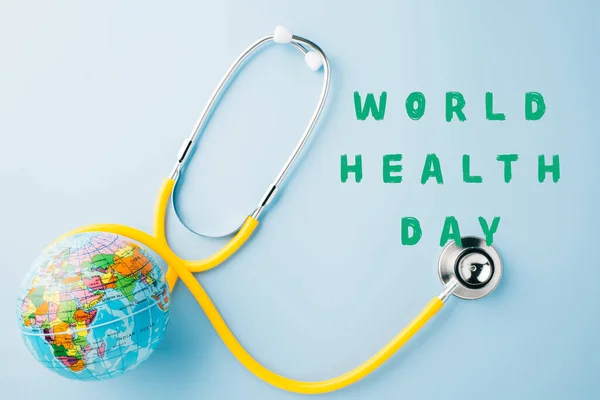 Weltgesundheitstag Gelbes Arzt Stethoskop Und Weltkugel Isoliert Auf Blauem Hintergrund — Stockfoto