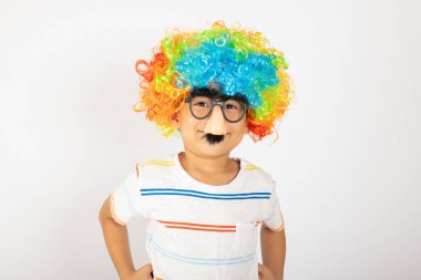 1 Nisan şakası. Komik çocuk palyaço portresi kıvırcık bir peruk takar. Renkli bir peruk takar. Gözlük takar.