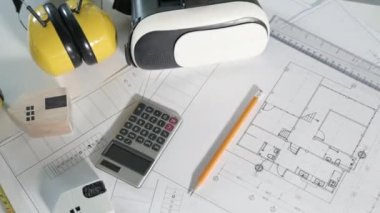 Mimari işyeri üst görünümü. Mimari proje planları masa üzerinde, mühendislik müteahhitlerinin tasarım için araç çalışma çizimi ve VR gözlükleri, sanayi sanal teknolojisi