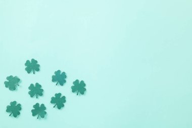 Happy St. Patricks Day decoration background. Flat lay of cutting paper clover leaves festive decor, shamrocks leaves holiday symbol with copy space on colour background, Banner greeting card concept