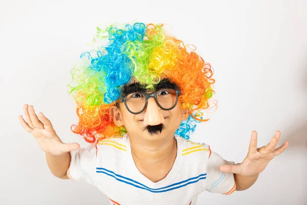 stock image April Fools Day. Two brothers funny kid boy clown wears curly wig colorful big nos and glasses and has mustache playing fool isolated on white background with copy space, Happy child festive decor