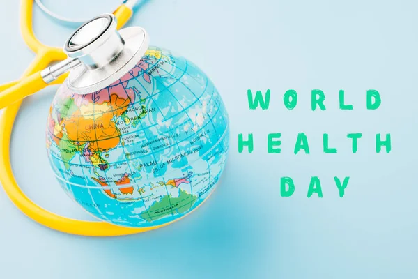世界保健デーのコンセプト トップ表示黄色の医師の聴診器とコピースペースでパステルブルーの背景に隔離された世界を世界を保存 環境緑の地球 健康管理と医療 — ストック写真