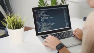 Programmer woman writing program HTML code sitting at workplace in office, IT software developer hands typing data coding programming with laptop computer, IT start up concept, Web application design