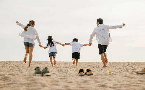 母亲和孩子们在沙滩上脱鞋 带着孩子与家人欢欢喜喜地手牵手跑到海滩度假 积极的生活方式 快乐的家庭日 — 图库照片