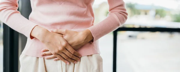 アジアの若い女性の不幸な体調不良の手を胃の上に保持自宅で痛みを受ける 月経から悲しい女性胃の痛み 腹部膨満感と慢性胃炎の概念 — ストック写真