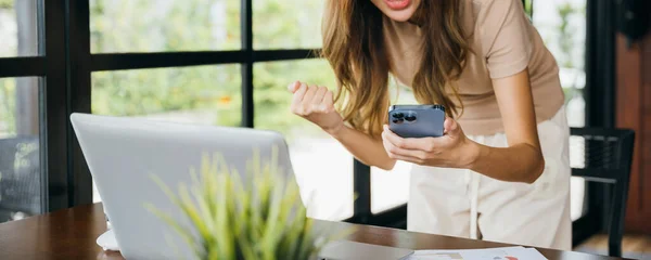 Захоплена Жінка Тримає Мобільний Смартфон Піднімаючи Руки Після Гри Онлайн — стокове фото