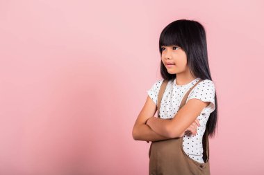 Asian little kid 10 years old smiling with arms crossed at studio shot isolated on pink background, Portrait of Happy confidence child girl lifestyle, Positive person