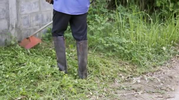 Çalışan Adam Dışarıda Çim Biçme Makinesiyle Çim Biçme Botu Giyer — Stok video