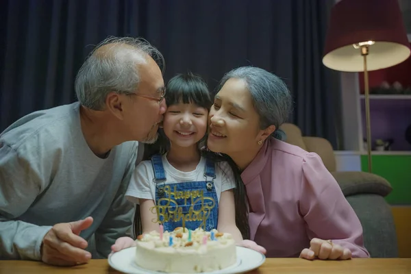 아시아인 할아버지와 할머니는 집에서아이와 고위층 파티인 케이크를 느끼며 손녀에게 맞추었다 — 스톡 사진