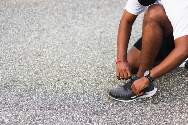 閉じるアジアのスポーツランナーブラックマンは 彼はランニングシューズを実行している靴をしようとして座って見て コピースペースと屋外ストリートヘルスパークを実行し 健康的な運動ワークアウトの概念 — ストック写真