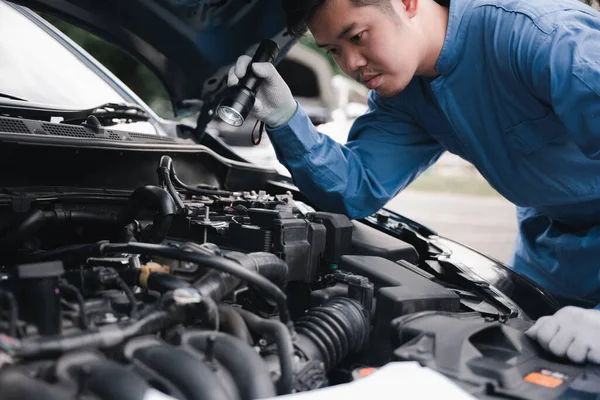 Asiatisk Man Mekaniker Blå Kostym Analysera Bilproblem Med Elektrisk Lampa — Stockfoto