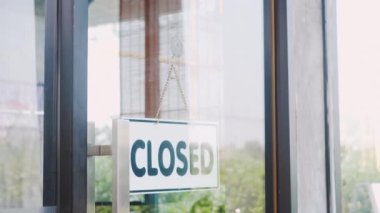 Mutlu Asyalı güzel bayan personel kapıyı açmak için tabela çeviriyor, kadın kahve dükkanı sahibi karantinadan sonra servisi açıyor, yeni bir normal açılış.