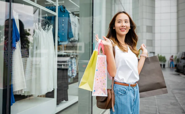市内でのショッピングセラピーバッグを手にした幸せな女性は 店の窓のディスプレイを賞賛します ファッション 消費主義 — ストック写真