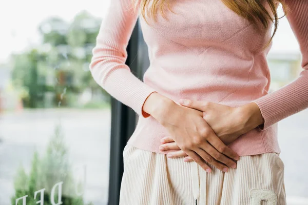 悲しい女性の胃の痛み月経から 若い女性の不幸な病気の手を胃の上に保持自宅で痛みを受けます 腹部膨満感と慢性胃炎の概念 — ストック写真