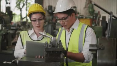 Asyalı profesyonel makine mühendisi kadın ve operatör üniforma ve gözlük takıyor güvenlik atölye metal torna fabrikası, ağır sanayi torna işçisi