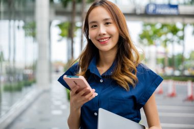 Güzel bir kadın cep telefonuyla mesajlaşırken yaz gününün tadını çıkarır. Bir şehir caddesinde duruyor, şehir hayatının koşuşturması ve telaşıyla çevrili..