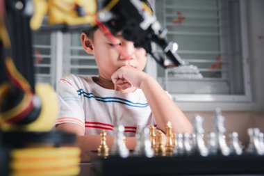 Asyalı küçük çocuk düşünüyor ve bekliyor satranç oynayan robot kolu, BTMM eğitimi E-öğrenen komik çocuklar başarılı bir ders kontrolü robot kolu oyunu, teknoloji bilimi eğitimi konsepti