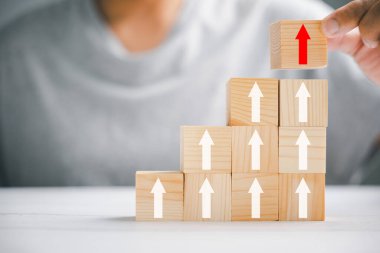 İş büyümesi ve başarı süreci kavramı. Yukarı doğru ok ile basamakları oluşturmak için ahşap blokları diziyorum. merdiven kariyer yolu performans artışını ve finansal potansiyeli simgeliyor