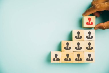 İnsan Kaynakları 'nın yetenek yönetimi ve adam toplamasını gösteren büyüleyici bir görüntü. Tahta küp bloktaki insan simgeleri takım çalışmasını temsil ediyor. Liderlik rolündeki kadın, iş başarısını vurguladı.