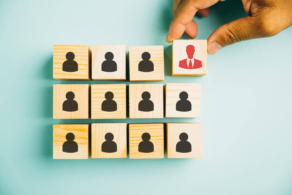 Creative stock photo illustrating human resources management and recruitment. Wooden cube block with an icon symbolizes the concept of building a successful business team.