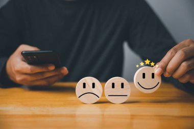 Tahta blok çemberinden gülen bir yüz seçmen mükemmel bir hizmet derecesi olduğunu gösteriyor. Müşteri memnuniyeti anketi konsepti 5 yıldızlı memnuniyet ve en iyi iş deneyimi.