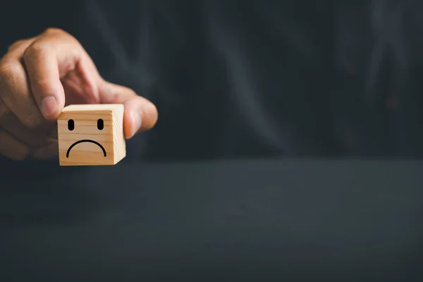 Unsatisfied customer expressing dissatisfaction on a wooden block. Concept of bad product quality, low rating, and negative comment. The impact of unsatisfied customers on business reputation.