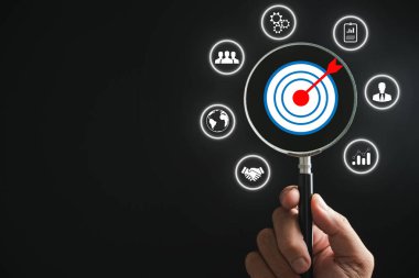 Büyüteç, hedef simgeye odaklanarak başlangıç, yaratıcı fikirler ve yenilikleri sembolize eder. Ticarette hedeflenen müşteri için motivasyon, planlama, geliştirme ve liderlik anlamına gelir