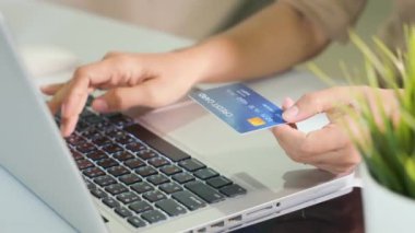 Bilgisayardaki kredi kartlarıyla kadın kaydı elektronik ödeme güvenliğini çevrimiçi yapıyor, kadın eli kredi kartı tutuyor ve evde ürün satın alımıyla dizüstü bilgisayar kullanıyor, internet üzerinden alışveriş kavramı